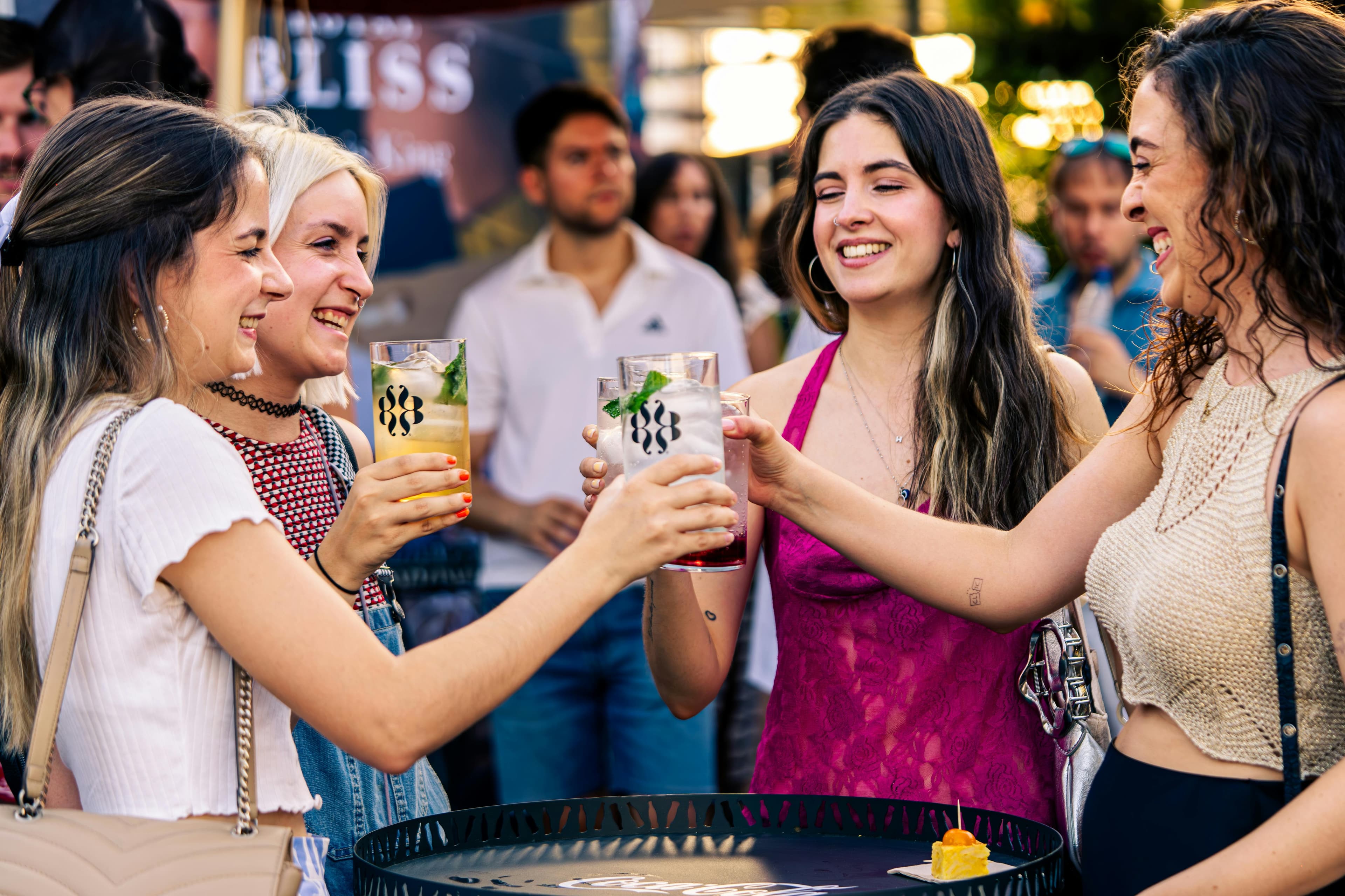 Crew cheers-ing colourful cocktails at a summer outdoor event