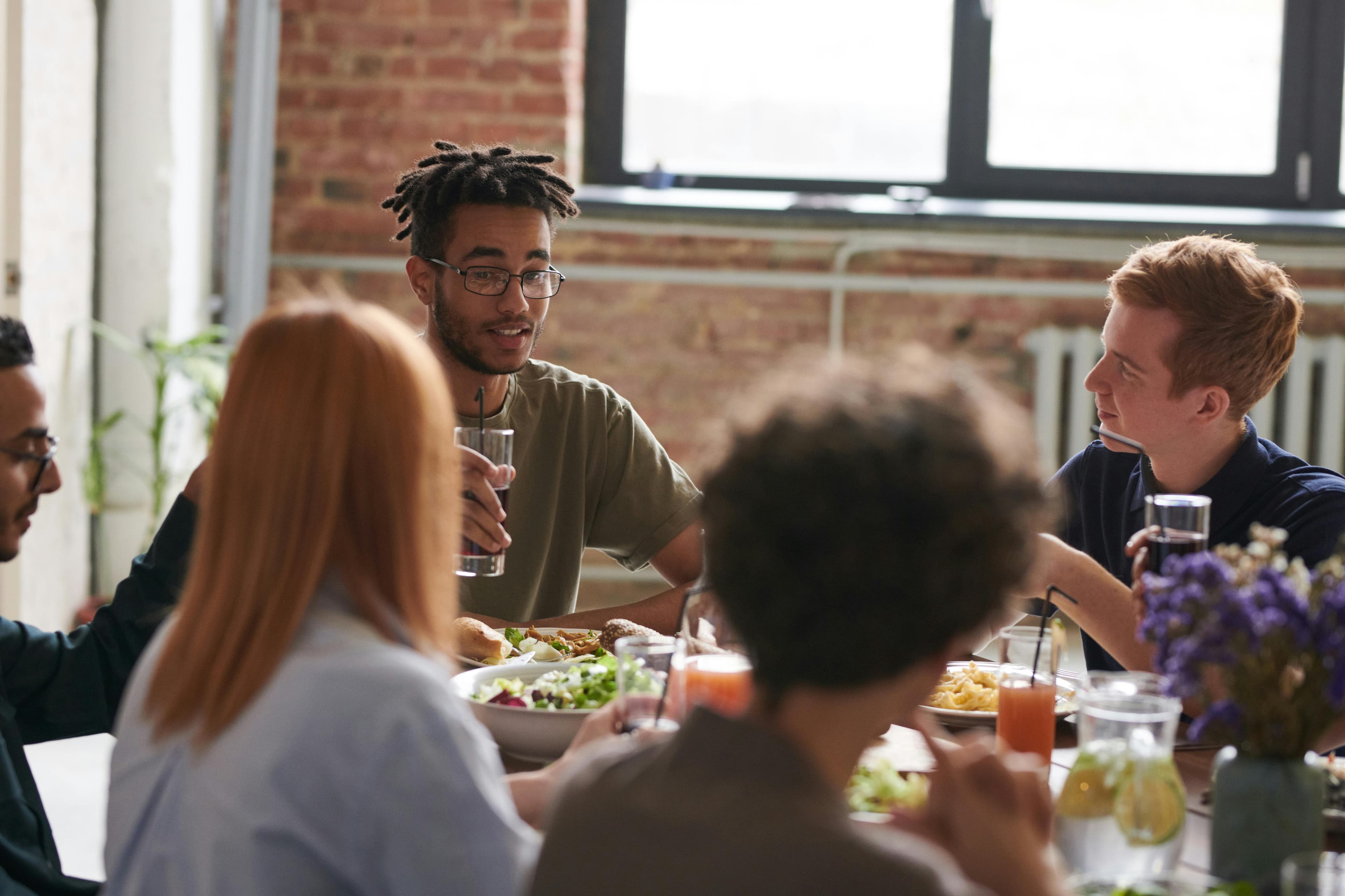 A mixed group around a brunch table — drinks, salad, easy conversation